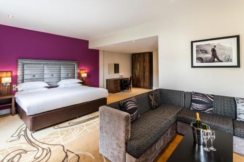 um quarto de hotel com uma cama e um sofá em The Daffodil Hotel & Spa em Grasmere