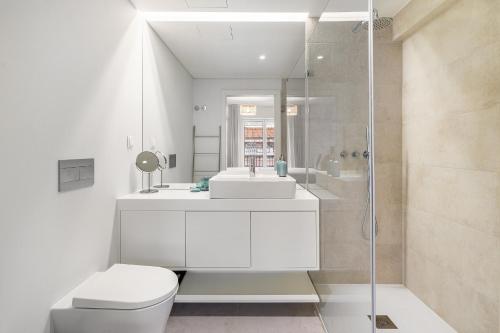 La salle de bains est pourvue de toilettes, d'un lavabo et d'une douche. dans l'établissement WHome Urban Oasis: Modern Living with Parking & AC, à Lisbonne