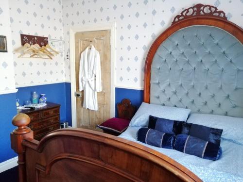 um quarto com uma cama grande e uma cabeceira em madeira em Glenart House em Tramore