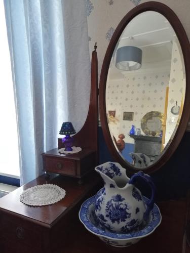 a table with a mirror and a vase on a table at Glenart House in Tramore