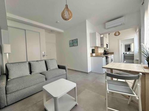 un salon avec un canapé et une table et une cuisine dans l'établissement Bertaina - Studio cosy Gare - Libération, à Nice