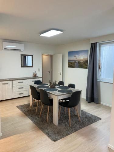 a dining room with a table and black chairs at Appartement Anthony in Blankenberge