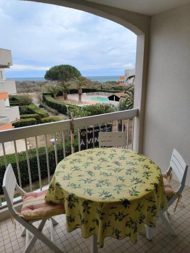 einen Tisch und Stühle auf einem Balkon mit Aussicht in der Unterkunft St Cyprien terrasse superbe vue sur la plage in Saint-Cyprien