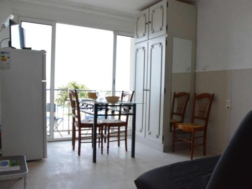 une salle à manger avec une table et des chaises et un balcon dans l'établissement Studio face à la mer, balcon et local à vélo, 300m du centre - Narbonne Plage - FR-1-229B-61, à Narbonne