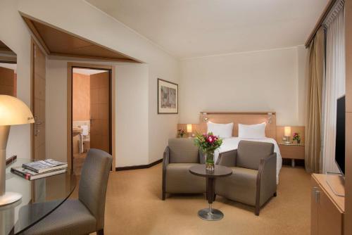 ヴィッラノーヴァにあるNH ボローニャ ヴィラノヴァのベッド、テーブル、椅子が備わるホテルルームです。