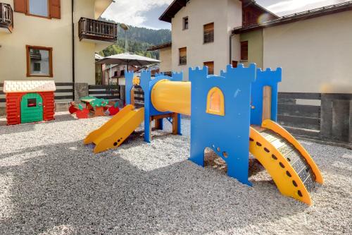 a playground with colorful play equipment in front of a building at Hotel La Nuova Montanina in Auronzo di Cadore