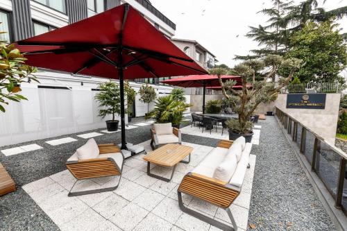 une terrasse avec des chaises, une table et un parasol dans l'établissement The Public Ortakoy, à Istanbul
