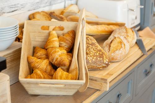 - un petit-déjeuner composé de pains et de viennoiseries sur un comptoir dans l'établissement Hotel de La Paix, à La Rochelle