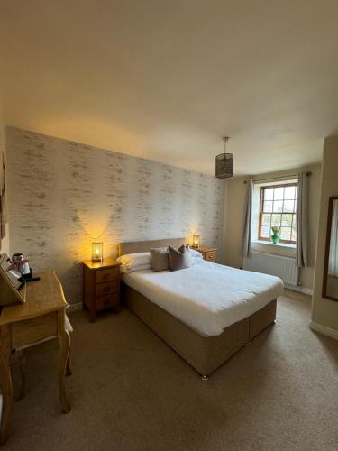 a bedroom with a large bed and a window at Sandfordarms in Appleby