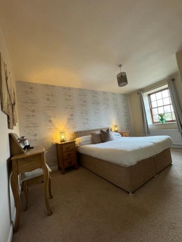 een slaapkamer met een groot bed en een raam bij Sandfordarms in Appleby