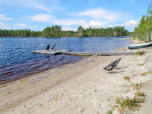 a person sitting on a dock on a lake at Holiday Home Kultahiekka by Interhome in Kivilahti