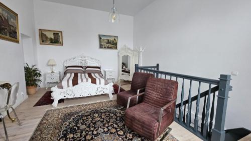 ein Schlafzimmer mit einem Bett und einem Stuhl neben einer Treppe in der Unterkunft Apartament Przy Jeziorze in Ostróda