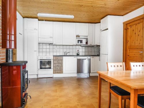 a kitchen with white appliances and a wooden table at Holiday Home Lomahuoneisto b by Interhome in Utsjoki