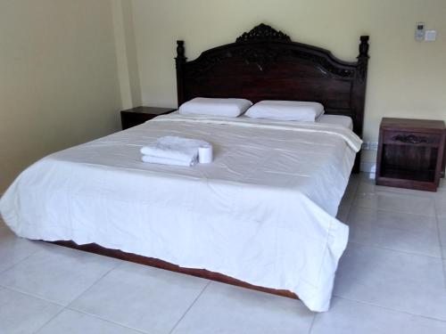 a large bed with white sheets and towels on it at Ubud Suites Batuan in Sukawati
