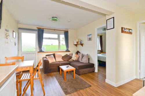 ein Wohnzimmer mit einem Sofa und einem Tisch in der Unterkunft 117 Sandown Bay in Sandown