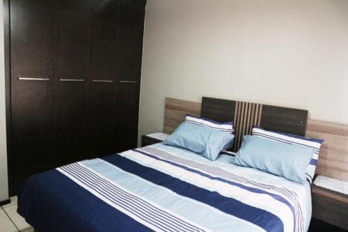 una camera con letto e lenzuola bianche e blu di Stone's Palace a Edenvale