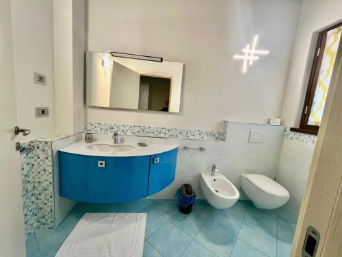 ローヴェレにあるIl Bacio del soleの洗面台、トイレ、鏡のあるバスルーム