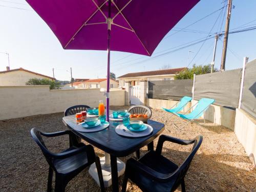 - une table avec un parasol violet sur la terrasse dans l'établissement Holiday Home Bolleau by Interhome, à Royan