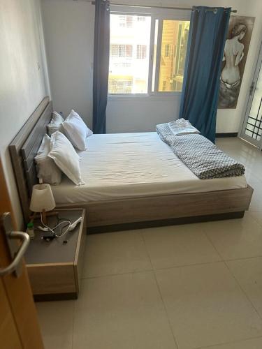a large bed in a room with a window at saveliving in Dakar