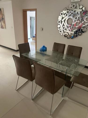 una mesa de comedor de cristal y sillas en una habitación en saveliving, en Dakar