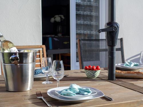 une table en bois avec des assiettes et des verres à vin dessus dans l'établissement Holiday Home Les Pêcheries by Interhome, à Pornic