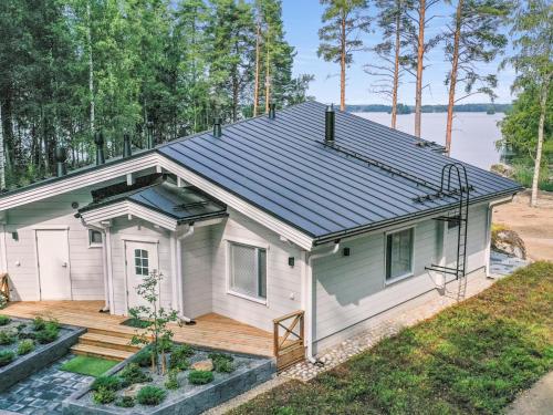 a small white house with a wooden deck at Holiday Home Palanteen haavelinna by Interhome in Eräjärvi