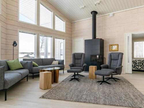 a living room with a couch and chairs and a fireplace at Holiday Home Palanteen haavelinna by Interhome in Eräjärvi