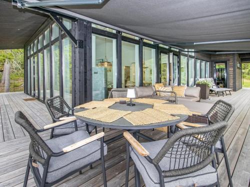 eine Terrasse mit Tisch und Stühlen auf einem Deck in der Unterkunft Holiday Home Villa katarina by Interhome in Nauvo