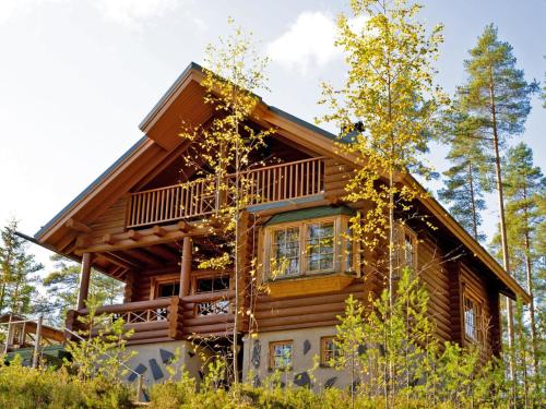 uma cabana de madeira na floresta com árvores em Holiday Home Villa tunturitervakko by Interhome em Ylämylly