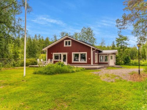 une maison rouge avec une cour devant elle dans l'établissement Holiday Home Villa kuorinka by Interhome, 