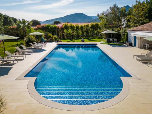 ソレードにあるLa villa du parcの椅子とパラソル付きのスイミングプールのイメージ