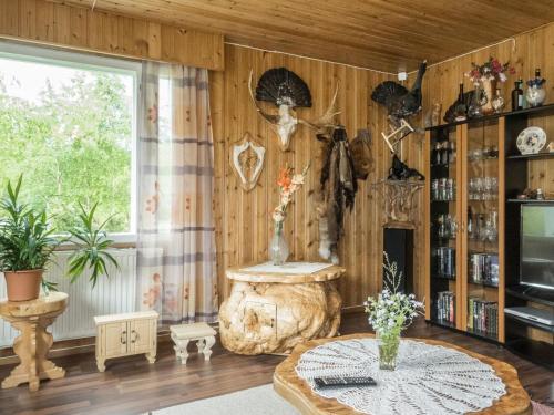 een woonkamer met houten wanden en een tafel met bloemen bij Holiday Home Käpylä by Interhome 