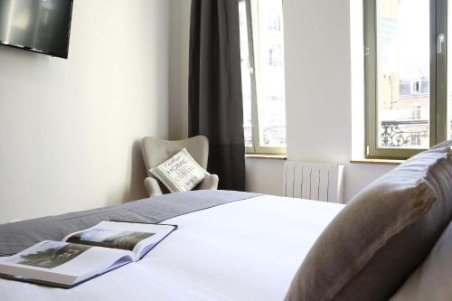 - une chambre avec un lit, un livre et une fenêtre dans l'établissement Flandres Appart' Hotel par NOCNOC, à Lille