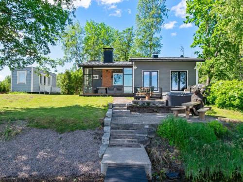 ein winziges Haus mit einer Terrasse und einem Hinterhof in der Unterkunft Holiday Home Lisan ranta by Interhome in Toijala