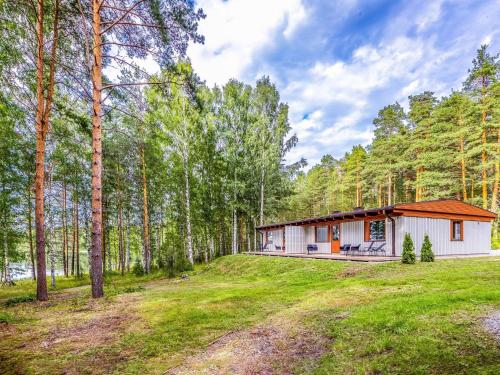 ein kleines weißes Haus im Wald mit Bäumen in der Unterkunft Holiday Home Mäntyranta 4 by Interhome in Punkaharju