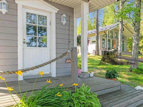 una casa con un porche de madera con flores en Holiday Home Villa honkarinne by Interhome en Jyväskylä