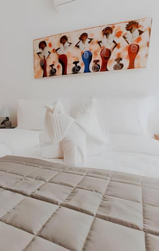 a painting hanging on a wall next to a bed at Familia Pansini casa na Pipa in Pipa