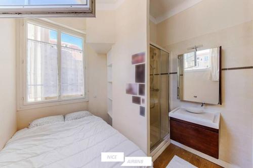 une petite chambre avec un lit et un lavabo dans l'établissement Barberis - Appartement cosy 2 pièces à proximité du port, à Nice