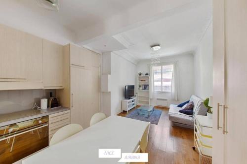 une cuisine et un salon avec une table et un canapé dans l'établissement Barberis - Appartement cosy 2 pièces à proximité du port, à Nice