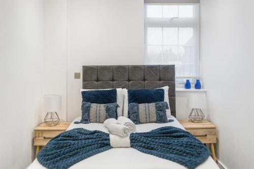a bedroom with a large bed with blue pillows at Welcoming and Spacious Apartment- Excellent Location in London