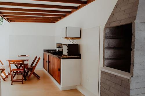 a kitchen and dining room with a brick wall at Familia Pansini casa na Pipa in Pipa