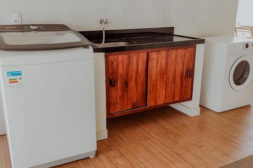 a kitchen with a sink and a washing machine at Familia Pansini casa na Pipa in Pipa