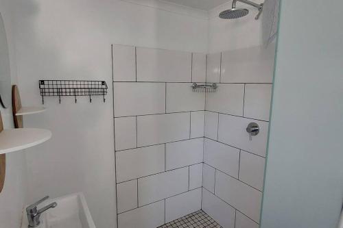 een witte badkamer met een douche en een toilet bij Studio garden cottage in Kaapstad