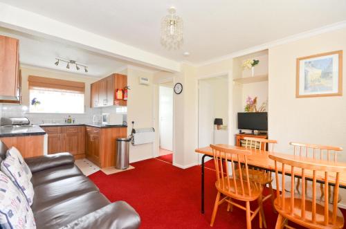 cocina y sala de estar con mesa y sofá en 162 Sandown Bay Holiday Park, en Sandown