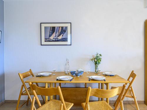 une table en bois avec des chaises et une salle à manger dans l'établissement Apartment Les Terrasses de la Plage by Interhome, à Carnac