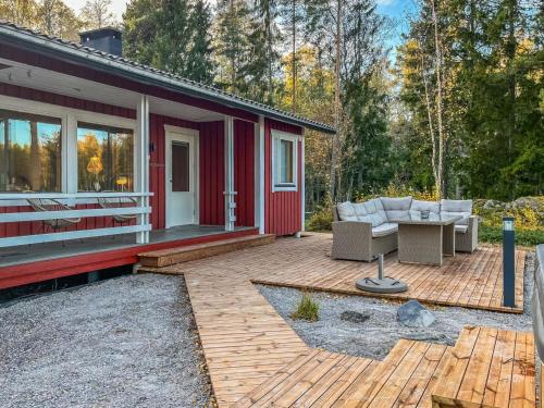 a red house with a patio with a couch and a table at Holiday Home Villa haave by Interhome 