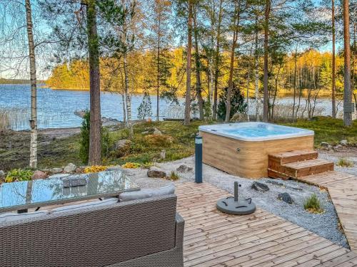 a hot tub sitting on a patio next to a body of water at Holiday Home Villa haave by Interhome 