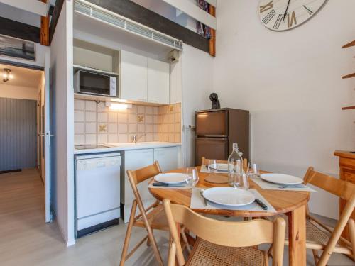 een keuken met een tafel en stoelen en een koelkast bij Apartment Les Terrasses Notre Dame du Port-9 by Interhome in Capbreton
