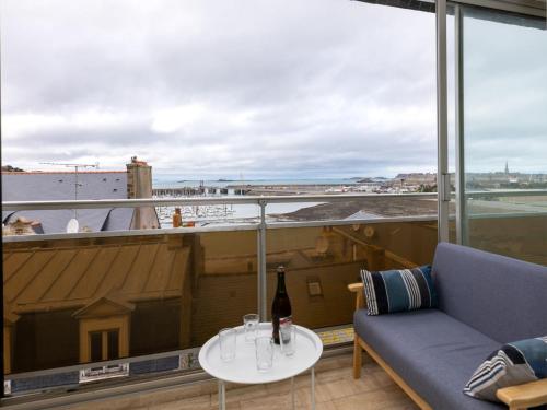 Cette chambre comprend un canapé et une table avec une bouteille de vin. dans l'établissement Apartment Bas-Sablons by Interhome, à Saint-Malo