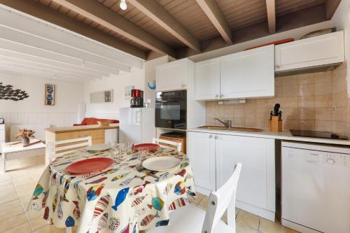 une cuisine avec une table avec des assiettes dessus dans l'établissement Évasion et détente à Saint-Gildas-de-Rhuys, à Saint-Gildas-de-Rhuys